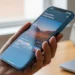 A close-up of a renewed iPhone 15 Pro in Blue Titanium, showcasing its premium titanium design and bright screen.