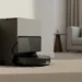 The Roborock S8 MaxV Ultra docked against a wall in a carpeted living room corner.