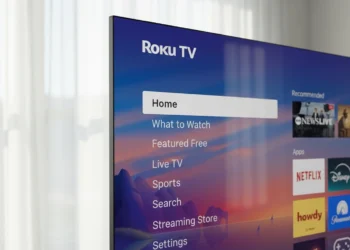 Close-up corner of a slim Roku Pro Series TV next to sheer curtains.