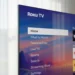 Close-up corner of a slim Roku Pro Series TV next to sheer curtains.