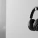 Black Bose wireless headphones hanging on a minimalist cylindrical wall mount.